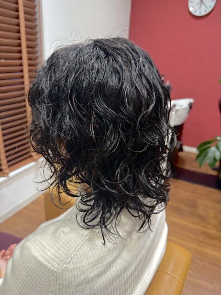 ウルフカットのくせ毛活かしの女性の写真