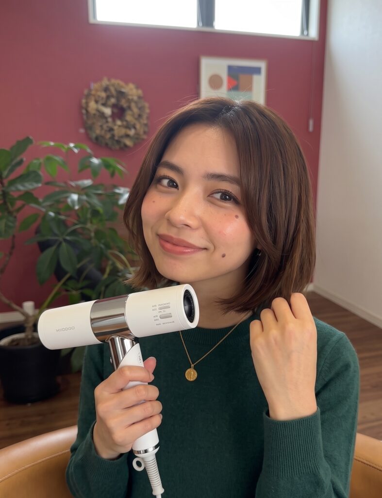ドライヤーを持って髪をケアしている女性